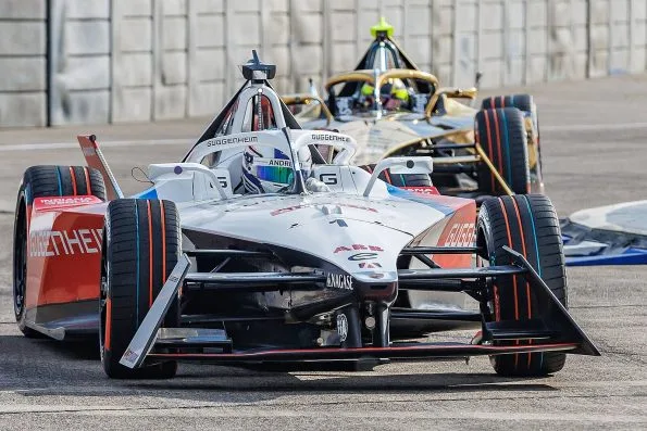 Jake Dennis's white and red Andretti Formula E car at the 2024 Berlin E-Prix, with a rival car close behind.
