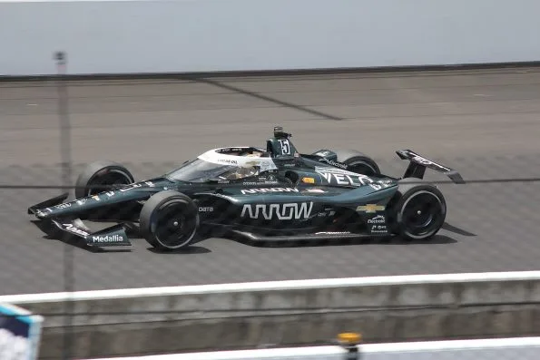 Pato O'Ward's dark Arrow McLaren car, number 5, leading on the Indianapolis Motor Speedway banking during the 2023 Indianapolis 500.